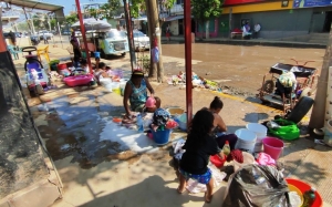 Habitantes de Acapulco lavan su ropa en las calles tras el paso de Otis